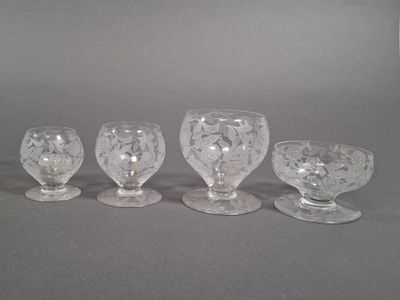four clear glass goblets sitting next to each other on a table