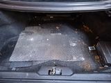 the trunk of a car with a metal floor mat in the trunk