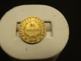une image représentant une pièce d'or posée sur un objet blanc