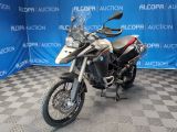 a picture of a motorcycle parked in front of a blue backdrop