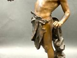 bronze statue of a man holding a bird in his hand