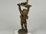 an antique bronze figurine of a boy holding a cup and saucer