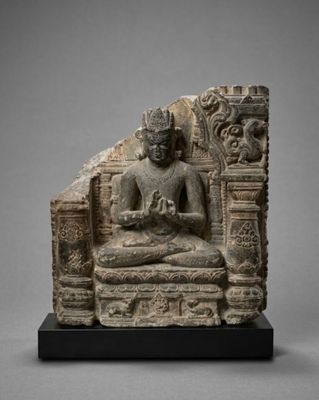 a stone statue of a seated buddha on a platform