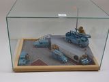 une vitrine en verre contenant un camion miniature et d'autres véhicules