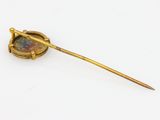 a gold plated broochle with a glass in the middle of it