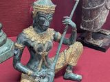 une statue représentant une femme assise sur une table rouge