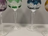 four wine glasses are lined up in a row on a table