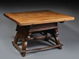 an old wooden table with a wooden top sitting on a gray surface