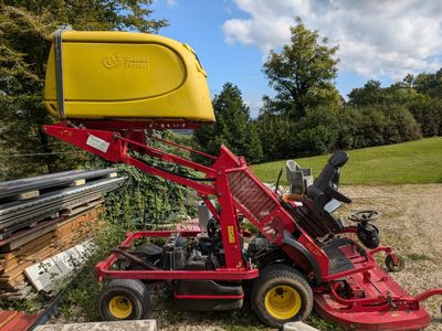 a small red tractor with a yellow box on top of it