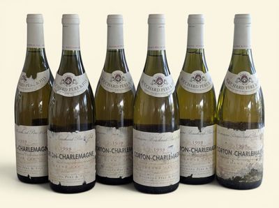 six bottles of wine are lined up in a row on a white surface