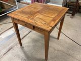 a small wooden table with a drawer on top of it