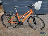 an orange bicycle parked in front of a blue garage