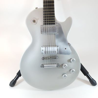 a guitar that is sitting on a stand on a white background