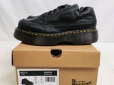 un gros plan sur une paire de chaussures noires posées sur une boîte