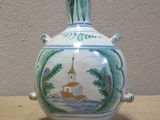 a small vase with a painting on it on a table