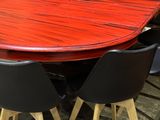 a red table with black chairs in a room