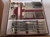 silverware in a red case on a table with red and white stripes
