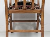 a wooden chair with a seat that has a cushion on it