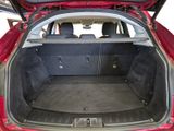the back of a red car with its trunk open and the seats down