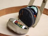 a purse with a cell phone in it on a tray
