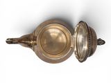 a silver teapot with a lid on a white surface