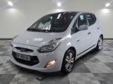 la petite voiture blanche est garée dans une grande pièce