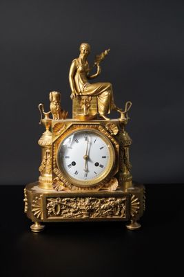 une horloge en or posée sur une table noire