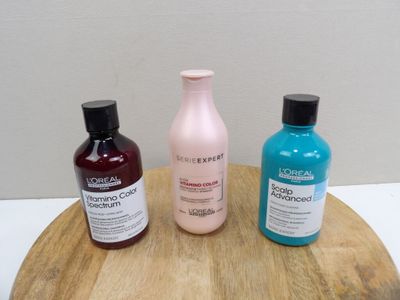 three bottles of hair care products sitting on a wooden tray