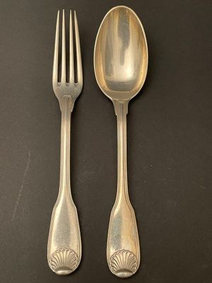 two forks and a spoon on a black surface