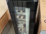 a black refrigerator with a glass door next to a cardboard box