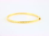 un bracelet rigide en or orné de petits points
