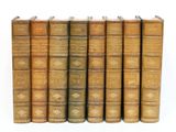 plusieurs vieux livres sont alignés sur une surface blanche