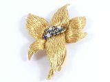 yellow flower brooch with blue and white stones on it