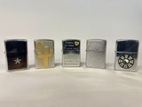 quatre briquets Zippo différents sont alignés sur une surface blanche