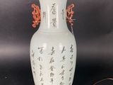 a white vase with asian writing on it on a table