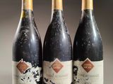 three bottles of wine sitting on top of a table next to each other