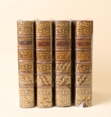 quatre livres sont alignés sur une surface blanche