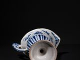 blue and white porcelain cup on a black surface with a black background