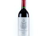 a bottle of red wine sitting on top of a white table