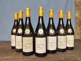 six bottles of wine are lined up on a wooden table