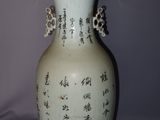 a white vase with asian writing on it on a table