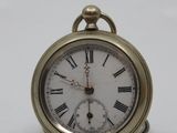 a small gold pocket watch with roman numerals on it