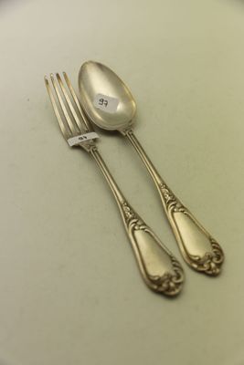 deux cuillères en argent et une fourchette sur une assiette blanche