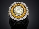 a yellow and white diamond ring on a black surface
