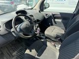 une voiture garée sur un parking, avec une camionnette en arrière-plan