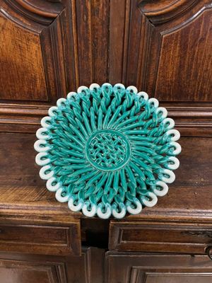 assiette décorative verte et blanche posée sur un meuble en bois