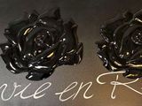three black roses that are on a black table