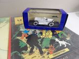 a small toy car in a blue box on top of a book