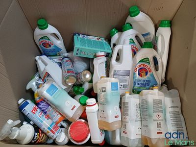 une boîte en carton remplie de produits d'entretien et d'autres articles ménagers