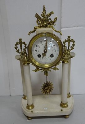 a white and gold clock sitting on top of a table